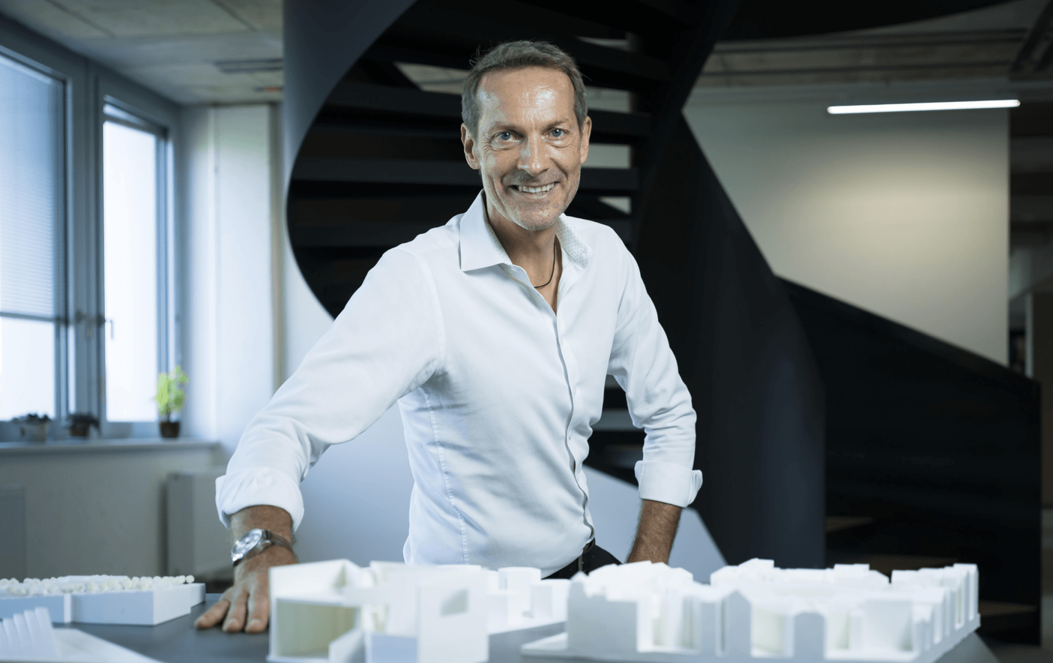 Architect Presents Architectural Model in a Modern Office with a Staircase